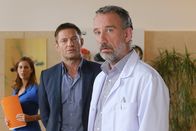 Die Rosenheim-Cops – Das Opfer wollte die Gemeinschaftspraxis mit Dr. Behring (Heio von Stetten, r.) und Julia Stemmer (Katharina Schwarzmaier, l.) zugunsten einer eigenen Praxis verlassen. Hansen (Igor Jeftic, M.) glaubt, dass der Arzt daraufhin zugeschlagen hat.