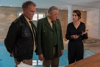Hubert ohne Staller – Hubert (Christian Tramitz, l.) und Girwidz (Michael Brandner, M.) sind bei der Trauerfeier von Dr. Holzer. Sie müssen zusammen mit der Witwe (Bianca Hein, r.) feststellen- die Leiche hat noch beide Füße.