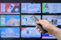Dauerwerbesendung – jemand, der mit einer Fernbedienung in der Hand TV-Home-Shopping-Kanäle durchsucht