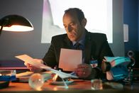 Mayday - Alarm im Cockpit – Der französische Flugunfallermittler Alain Bouillard (gespielt von Mark Caven) bei der Arbeit an seinem Schreibtisch während der Untersuchung des Absturzes der Air France 4590. Die Überschallmaschine Concorde war kurz nach dem Start am 25. Juli 2000 in Flammen aufgegangen und abgestürzt.