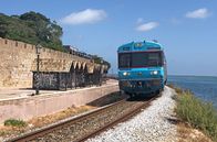 alpha-expedition: Mit dem Zug ... – Einfahrt in Faro: Der Zug fährt zwischen der Lagune und der Stadtmauer der Altstadt entlang.