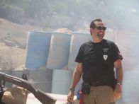 Die Waffensammler – Sean Rich smiling in satisfaction surrounded by gun smoke after successfully firing a swivel blunderbuss.