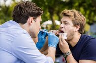 In aller Freundschaft - Die jungen Ärzte – Florian Osterwald (Lion Wasczyk, l.) versucht etwas aus Mikko Rantalas (Luan Gummich, r.) Mundraum zu entfernen. Kann er ihm helfen?