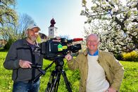 Eine Reise ins Paradies - Auf der Steirischen Apfelstraße – Kameramann Walter Schöggl und Gestalter Robert Sturmer bei den Dreharbeiten im blühenden Apfelgarten vor der Kirche von Puch bei Weiz.