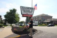 Hotel Impossible – Host Anthony Melchiorri strikes a pose in front of the sign for the Simmons Motel in Hershey, Pennsylvania, as seen on Travel Channel's Hotel Impossible.