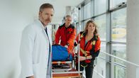 Die Bergretter – Nach der Bergung übergeben Katharina Strasser (Luise Bähr, r.) und Michael Dörfler (Robert Lohr, M.) die Verletzte an Dr. Nick Aichstetter (Nicholas Reinke, l.).