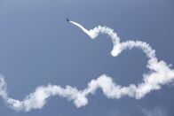 Airpower – Aerobatic plane with a white smoke trail in the blue sky.