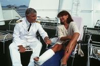 Das Traumschiff – 3. Kapitän Hansen (Heinz Weiss) spricht Beatrice (Heide Keller) Mut zu, die sich einen Bänderiß zugezogen hat und ob der vielen Probleme an Bord inzwischen schon an den Klabautermann glaubt.