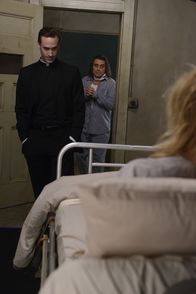 American Horror Story – Jahr 1964: Schwester Jude Martin (Jessica Lange, r.) kann nicht glauben, dass ihr einstiger Verbündeter Monsignor Timothy Howard (Joseph Fiennes, l.) ihr so etwas antut: Er bringt Emerson (Ian McShane, r.) an ihr Krankenbett ...