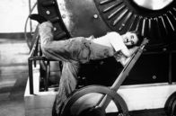 Moderne Zeiten – Trotz immer neuen Versuchen schafft es Charlie (Charlie Chaplin) nicht, in der neuen Arbeitswelt einen Job zu behalten.