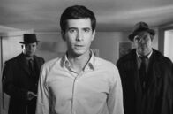 Der Prozess – Josef K. (Anthony Perkins, Mi.) wird eines Morgens völlig unerwartet von zwei Ermittlern (Billy Kearns, li., und Jess Hahn, re.) verhaftet.