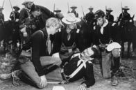 Rio Grande – Der junge Jeff (Claude Jarman Jr., li.) greift ein, um seinen verwundenen Vater Leutnant Colonel Yorke (John Wayne, am Boden) zu retten.