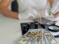 Deal Makers - Alles hat seinen Preis – Jewelry appraiser evaluates gold rings and chains alongside monetary cash on a table in a collection setting