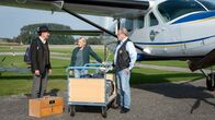 Die Küstenpiloten – Swantje (Nadine Boske) und Hauke (Jan-Gregor Kremp) checken das ungewöhnliche Fluggepäck des Passagiers Ralf Klingenberg (Oliver Törner, li.) ein.