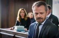 Sturm der Liebe – Erleichtert über Josies Befreiung, sagt Erik (Sven Waasner, vorne) gegen Ariane (Viola Wedekind, hinten) aus (mit Komparsin).