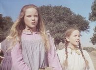 Unsere kleine Farm – Mary (Melissa Sue Anderson, l.) und Laura (Melissa Gilbert, r.) sind sehr neugierig auf ihren neuen Lehrer, der diesen Morgen seinen Dienst antritt.