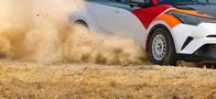 Rallye: Land der 1000 Hügel Rallye – Rallye-Rennwagen driftet in Kurve auf Feldweg.