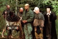 Stargate – Die gläubigen Bewohner (Darsteller nicht bekannt) wollen Teal´c (Christopher Judge, mi.) im See versenken. Sie testen, ob er ein Dämon ist. Kanonikus (Alan C. Peterson, re.) überwacht das Ritual...