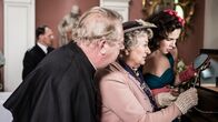 Father Brown – Mrs McCarthy (Sorcha Cusack, M.), Father Brown (Mark Williams, l.) und Bunty (Emer Kenny, r.) bewundern die detailgetreue Darstellung der Morde in den Dioramen. Noch ahnen sie nicht, dass es bald zu einem weiteren Mord kommen wird.