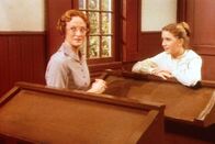 Unsere kleine Farm – Miss Wilder (Lucy Lee Flippin, l.) hat sich zum ersten Mal verliebt. Verlegen fragt sie Laura (Melissa Gilbert, r.), wie sie Harve Miller auf sich aufmerksam machen kann.