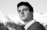 Die Theorie von Allem – Johannes Leinert (Jan Bülow) auf der Terrasse des Hotel Esplanade. 1962 reist er mit seinem Doktorvater Dr. Strathen zu einem Quantenphysik-Kongress in die Schweizer Alpen, doch der Redner, von dem eine Theorie von Allem erwartet wird, verspätet sich.
