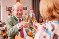 Die Rosenheim-Cops – Achtziger (Alexander Duda, l.) und Marie (Karin Thaler, r.) stoßen auf das gelungene Programmheft an.