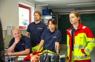 Watzmann ermittelt – Vor den Kommissaren mauern die Sanitäter Ritschi (Peter Finsterwalder, l.), Bruno (Timo Gasteger, 2.v.l.), Bertha (Vanessa Jung, 2.v.r.) und Luise (Sophie Röhrmoser, r.). Ist einer von ihnen der Mörder?