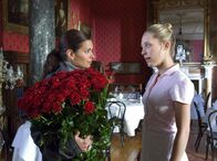 Der Zauber des Regenbogens – Lea (Sandra Speichert, li.) hat von ihrem Verflossenen einen Strauß Rosen geschickt bekommen und bittet Zimmermädchen Lucy (Marisa Leonie Bach), sie als Tischdekoration zu verwenden.