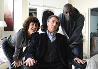 Ziemlich beste Freunde – Driss (Omar Sy, re.) und Yvonne (Anne Le Ny) putzen Philippe (François Cluzet) heraus.