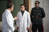 Charité – Otto (Jannik Schümann, M.) besteht sein Chirurgie-Examen bei Prof. Sauerbruch (Ulrich Noethen, l.). Sein Prüfungspatient ist kein Geringerer als Claus Schenk Graf von Stauffenberg (Pierre Kiwitt, r.).