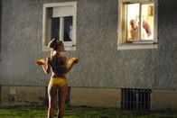 Pornorama oder die Bekenntnisse der mannstollen Näherin Rita Brauchts – Provokation: Luzi (Karoline Herfurth) stellt sich für Filmaufnahmen oben ohne vor das Fenster ihrer Nachbarn.