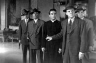 Ich beichte – Kriminalkommissar Larrue (Karl Malden, vo.re.) hält Pfarrer Michael Logan (Montgomery Clift, Mi.) zurück, während bewaffnete Polizisten bereitstehen.