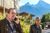 Watzmann ermittelt – Max (nicht im Bild) erstattet Beissl (Andreas Giebel, l.) am Telefon Bericht über seinen Spezialauftrag. Jerry Paulsen (Peter Marton) hört mit.