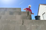 Handwerkskunst! – Maurer Daniel Marques beim Mauern des Erdgeschosses mit Bimssteinen.