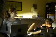 Internet der Lügen – Lacey looking at Wyatt on the couch while on her laptop.