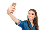Big Stories – Pretty young happy woman making selfie on smartphone