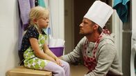 Vilda – Papa (Peter Kanerva) tröstet Vilda (Sofia Sittnikow). Ihr ist ganz übel von dem vielen Lebkuchenteig.