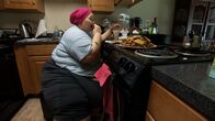 Mein Leben mit 300 kg – Brittani eating food in the kitchen.