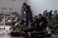 Mayday - Alarm im Cockpit – REENACTMENT - Inside an investigative hangar, the IAC on-site investigator (played by Drew Zeran) inspects what's left of the debris from the crash of Fly Dubai Flight 981, while the on-site assistant investigator documents their findings. (Cineflix 2021/Darren Goldstein)