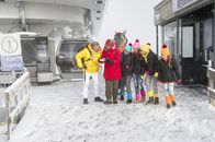 TanzAlarm – Schneewanderung in den Alpen. Singa, Volker Rosin und die TanzAlarm-Kids marschieren munter durch das verschneite Gelände und sehen nicht, wie sich der TanzTapir, angelockt von beschwingter Hüttenmusik, von der Truppe entfernt.