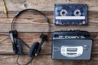 Guess the Year – Music concept. Top view of cassette tape, audio player and headphones.