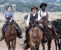 Dead for a Dollar – Max (Christoph Waltz, M.) mit seiner Gefangenen, Rachel (Rachel Brosnahan, l.) und seinem Begleiter Sergeant Poe (Warren Burke, r.)