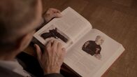 Ermittler! – Kommissar Bent Isager-Nielsen blättert durch ein Buch, das die größten Kriminalfälle der skandinavischen Geschichte behandelt. Darunter auch der Fall zum ermordeten Nhut. Die Pistole aus dem Fall ist durch die jahrelange Lagerung im Wasser komplett verrostet.