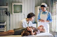 ORF-Premiere: Charité – Der kleine Werner (Hugo Gross, Mi.) wird mit Symptomen von Kinderlähmung in die Charité eingeliefert. Kinderärztin Dr. Ingeborg Rapoport (Nina Kunzendorf, li.) und Schwester Arianna (Patricia Meeden, re.) versuchen den Jungen zu beruhigen.