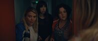 Derby Girl – Mother Blocker (Sophie-Marie Larrouy, l.), Absinthe-ni-touche (Suzanne de Baeque, M.) und Marie-Josée (Salomé Diénis Meulien, r.) finden heraus, dass jemand absichtlich die Tür mit Holzplatten versperrt hat und sie somit in der Turnhalle eingesperrt hat.