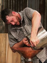 Moonshiners: Master Distiller – Travis pouring mash in his still