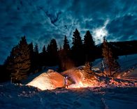Expedition Wild – WYOMING, USA: Naturalist Casey Anderson tends the fire outside his snow hut in Yellowstone National Park. Anderson has come to explore the physiological and behavioral characteristics of wolves, Yellowstone's top predator, on the fifteenth anniversary of their introduction into the park. (Photo Credit: