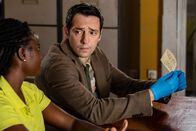 Death in Paradise – Im Polizeirevier untersuchen Naomi Thomas (Shantol Jackson, l.) und Detective Neville Parker (Ralf Little, r.) akribisch einen Zettel mit einem Hilferuf und führen entsprechende Nachforschungen durch.