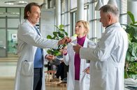 In aller Freundschaft – Klinikleiter Dr. Martin Stein (Bernhard Bettermann, li.) kann einen privaten Termin mit einer Maklerin nicht wahrnehmen. Seine besten Freunde Dr. Kathrin Globisch (Andrea Kathrin Loewig, mi.) und Dr. Roland Heilmann (Thomas Rühmann, re.) bieten ihm an, ihm diesen Termin abzunehmen.
