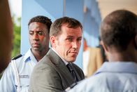 Death in Paradise – DI Richard Poole (Ben Miller, M.) geht es nicht darum, einen Fall möglichst schnell abzuschließen, sondern die Wahrheit herauszufinden. Unterstützt wird er dabei von seinen Kollegen der Polizei, wie Fidel Best (Gary Carr, l.).